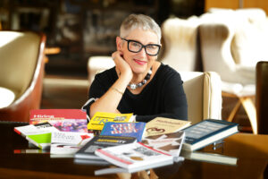 Cathy Fyock sitting at a desk with books scatteredin front of her
